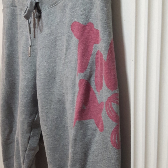 TNA grey sweatpants with pink design and logo